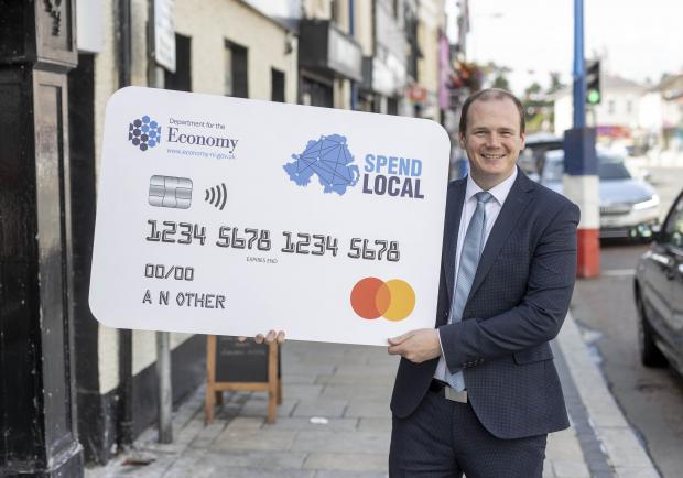 Economy Minister Gordon Lyons with a Spend Local card